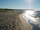 The trail leads to this beach. Look, the sun is shining! Its a beautiful day! How many people do you see?